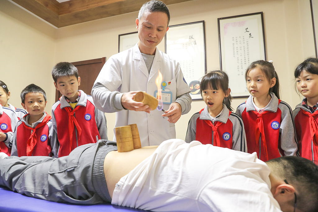 2023年10月20日，学生们在中国东部浙江省湖州的一个卫生中心观看拔罐疗法的演示。拔罐疗法是一种中国传统保健方法。/CFP